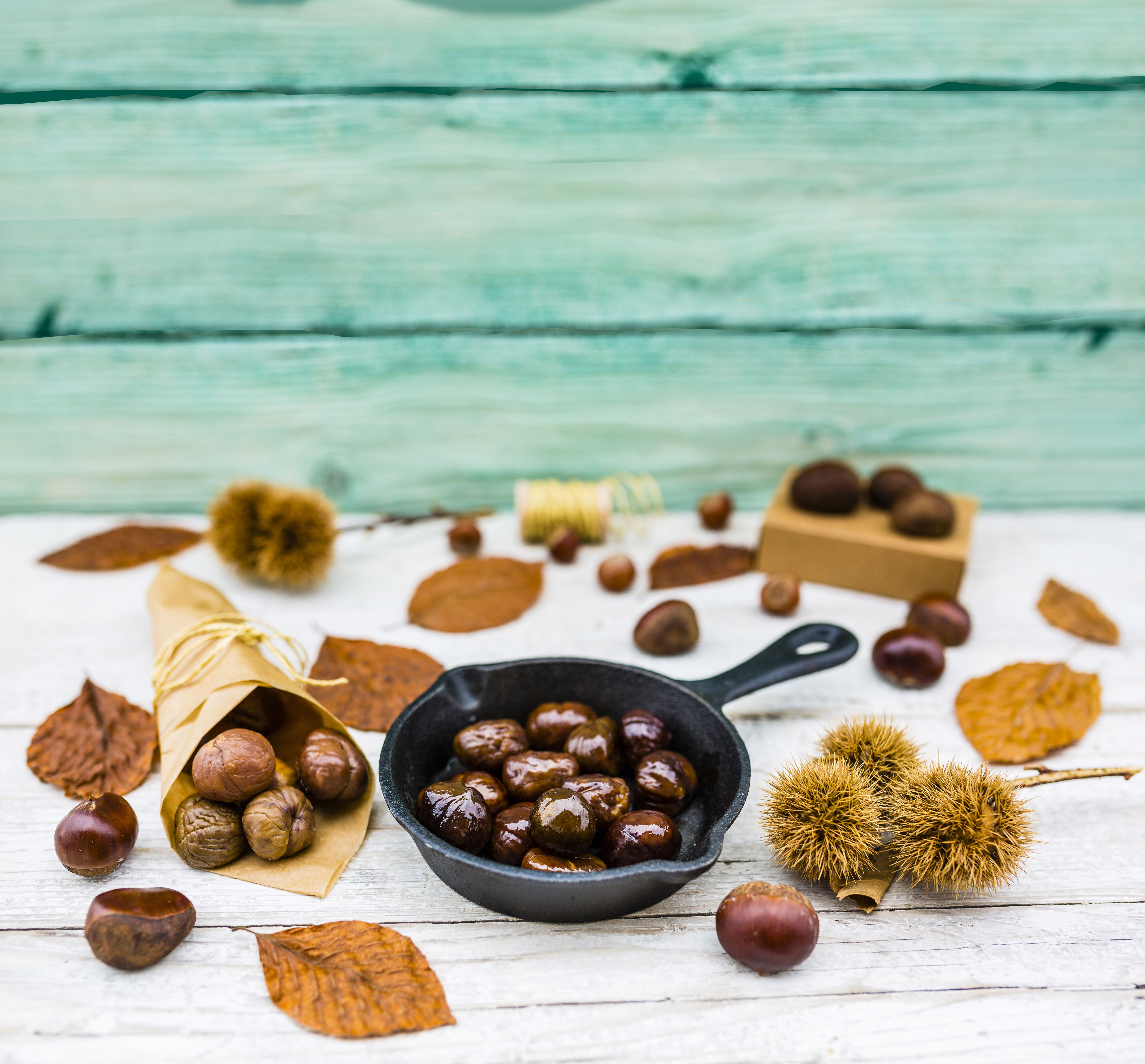Delicious and hot roasted chestnuts on frying pan on old wooden